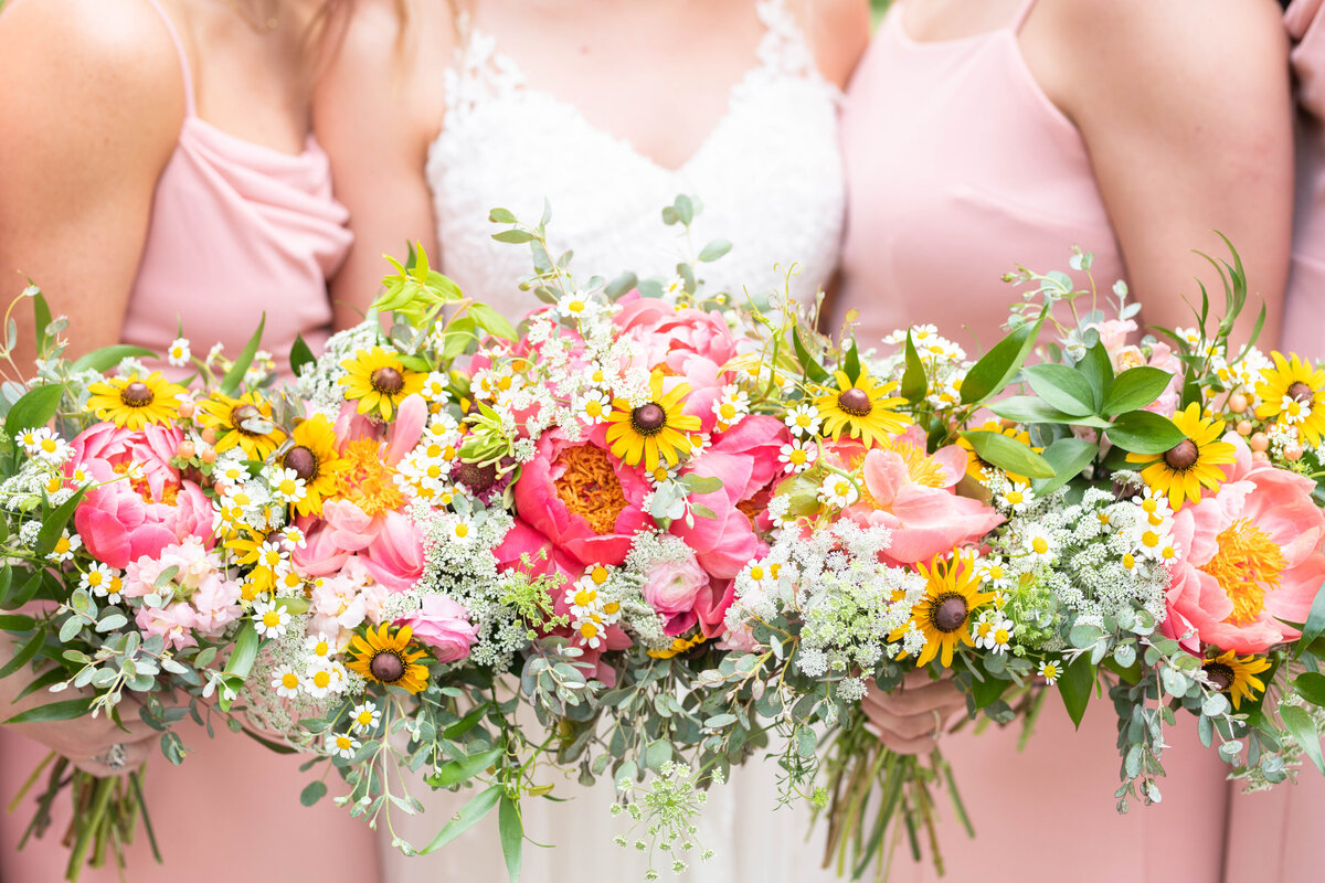 Bride and her bridesmaids hold wedding bouquets