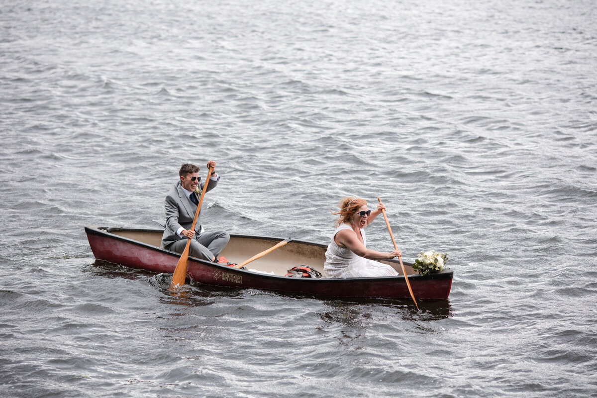Two brides paddle a canoe after getting married near the Connecticut river in Northfield ma