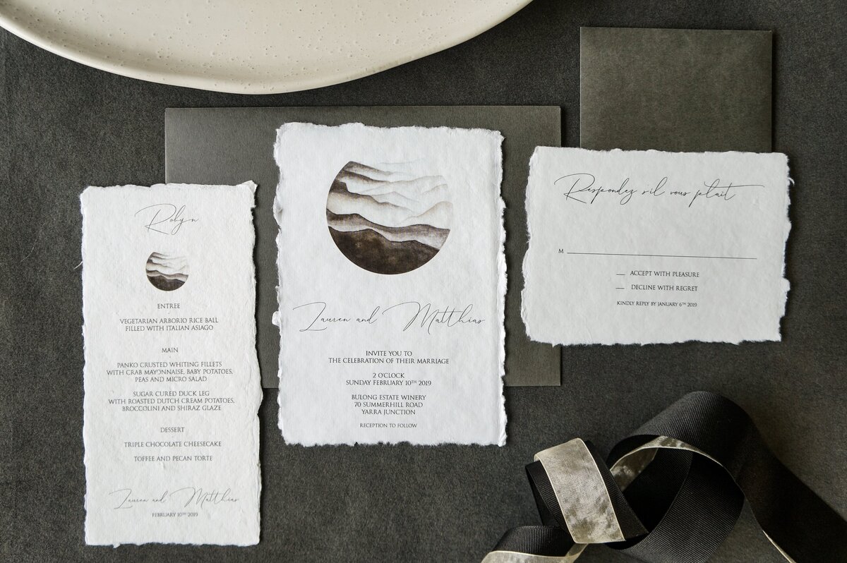 Handmade paper wedding invitations with soft edge and mountain design, matched with RSVP card and menu place card