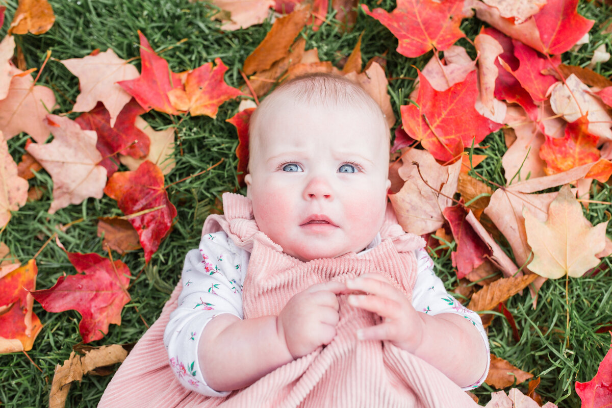 Newborn girl laying in leaves in Boston Public Garden