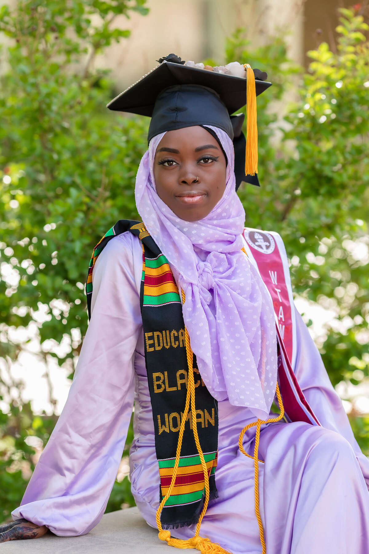 Nigerian woman senior session with eduacated black woman stole wearing cap and tassel in  a  lavender outfit at West Texas A&M (WTAMU) campus in Canyon TX