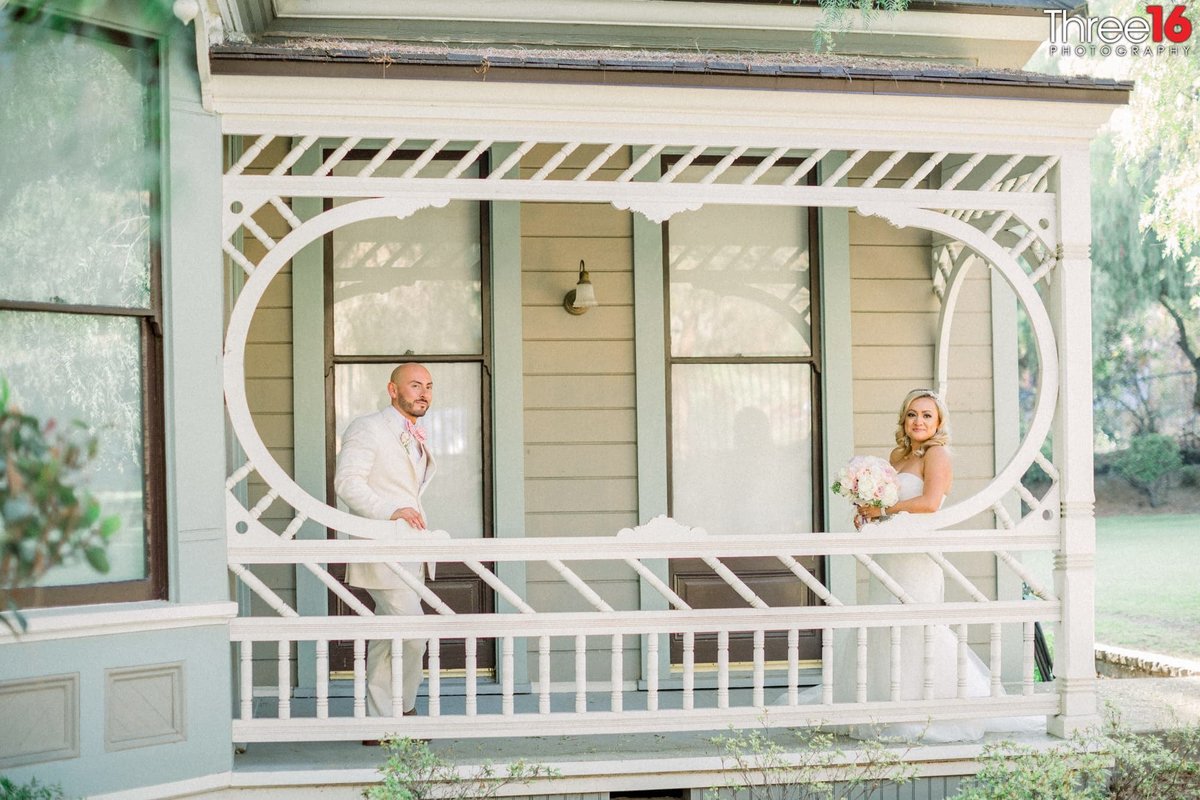 Bride and Groom standing on a porch posing for photos at the Brand Library Park wedding venue