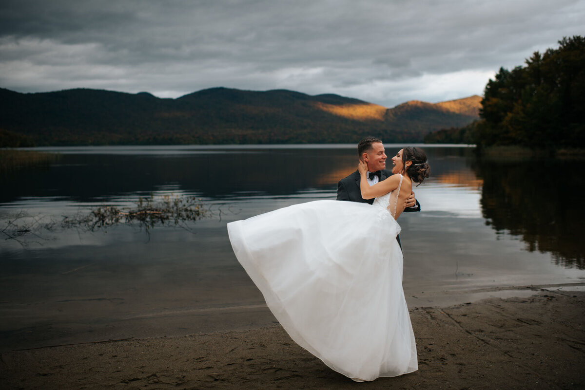 bride and groom dancing on beach at sunset in front of chittenden reservoir at mountain top inn