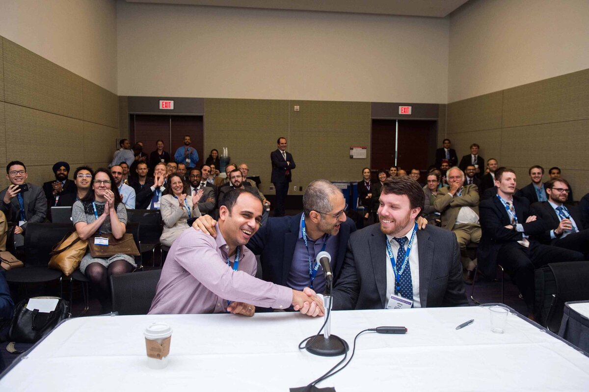 Ohio State neurosurgery residents win SANS Challenge and shake hands while audience behind them cheers at an Annual Meeting