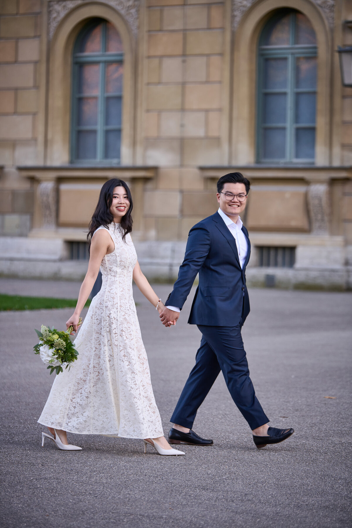 Vietnamese wedding couple walkig in front of the residence Munich.