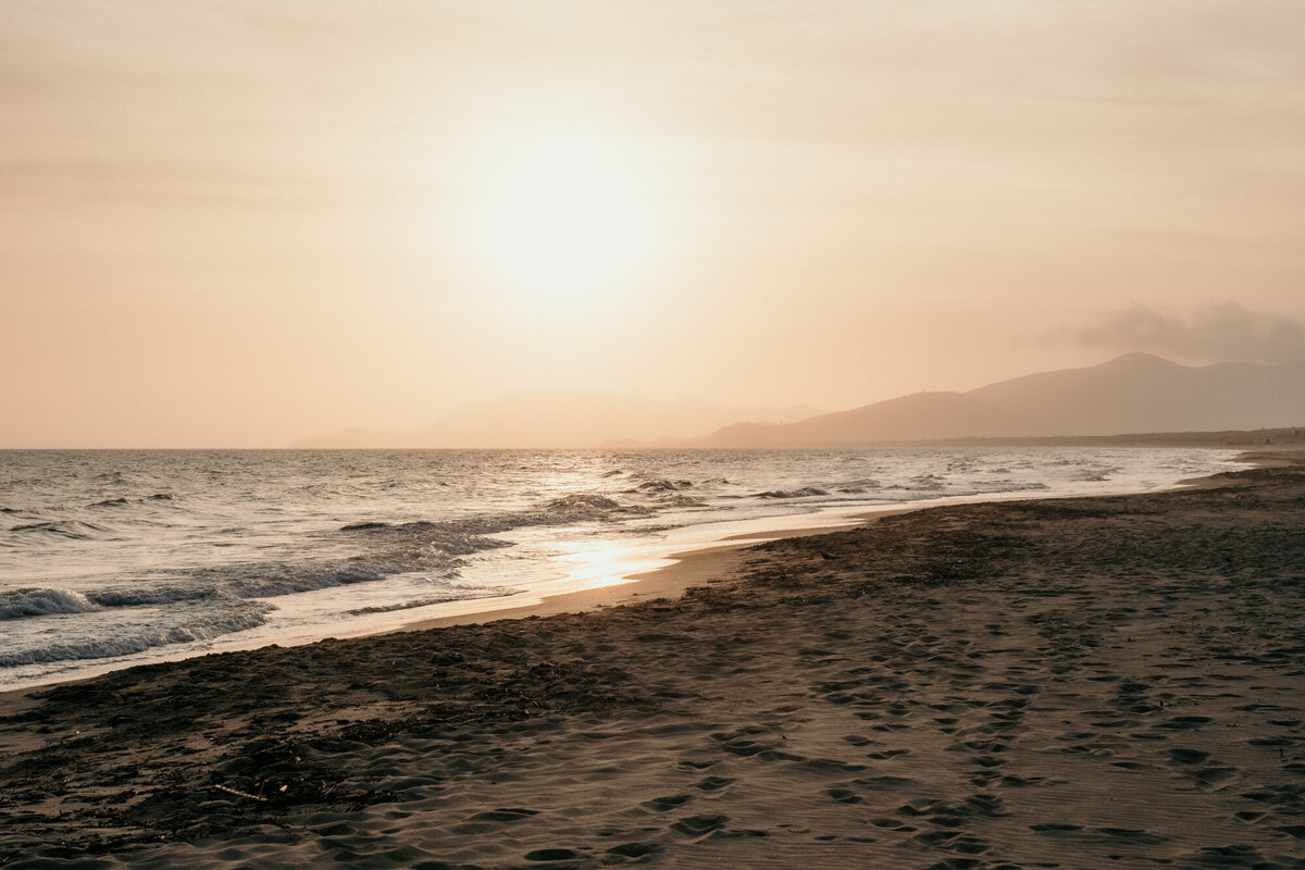 Diese Aufnahme zeigt das Farbenspiel des Sonnenuntergangs am Ufer des Strandes.