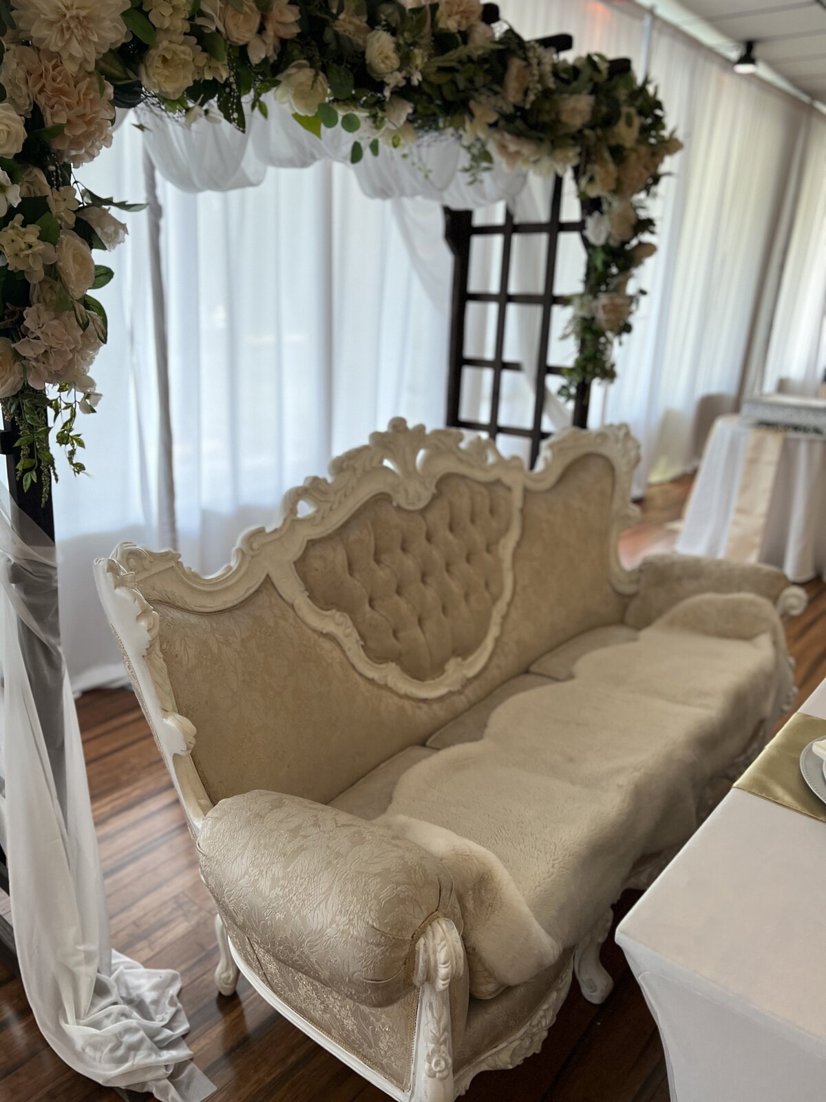 White Victoria couch at the head table for a grand reception of the bride and groom at our Clearwater banquet hall - Adding elegance and sophistication to their special day