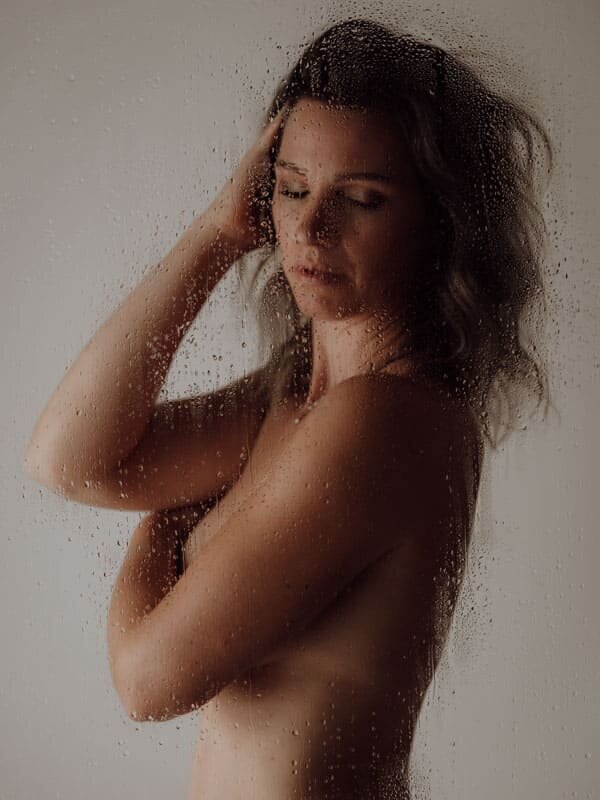 Intiem portret van vrouw die haar lichaam omarmt, symboliseert acceptatie en trots.