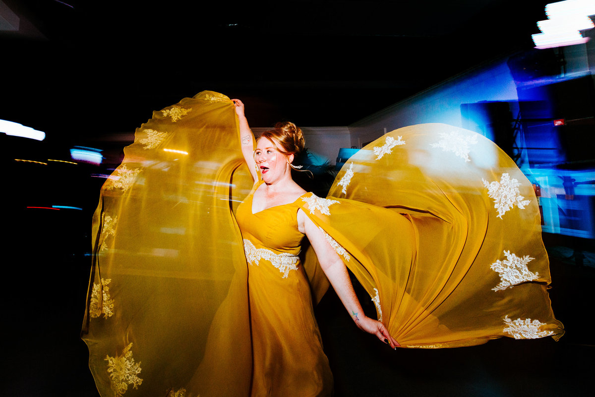 One of the top wedding photos of 2020. Taken by Adore Wedding Photography- Toledo, Ohio Wedding Photographers. This photo is of a bride in a custom yellow wedding gown dancing during the wedding reception at the Toledo Zoo