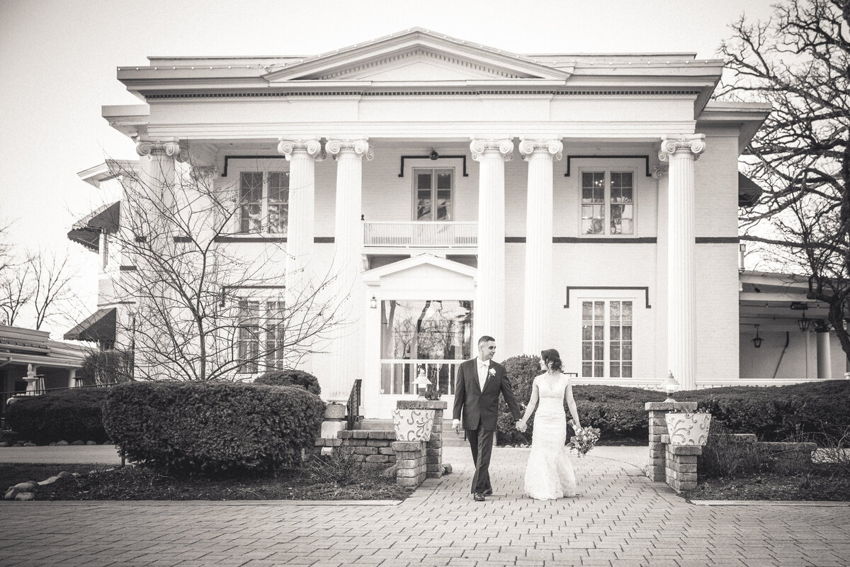 A classic wedding portrait of a bride and groom walking hand in hand at the Meson Sabika venue in Naperville, IL