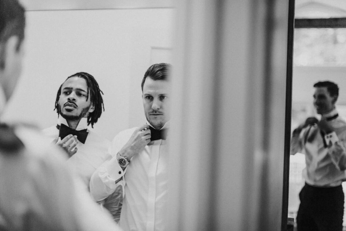 Black and White Candid Portrait of Groomsmen getting ready at a Luxury Michigan Lakefront Golf Club Wedding.