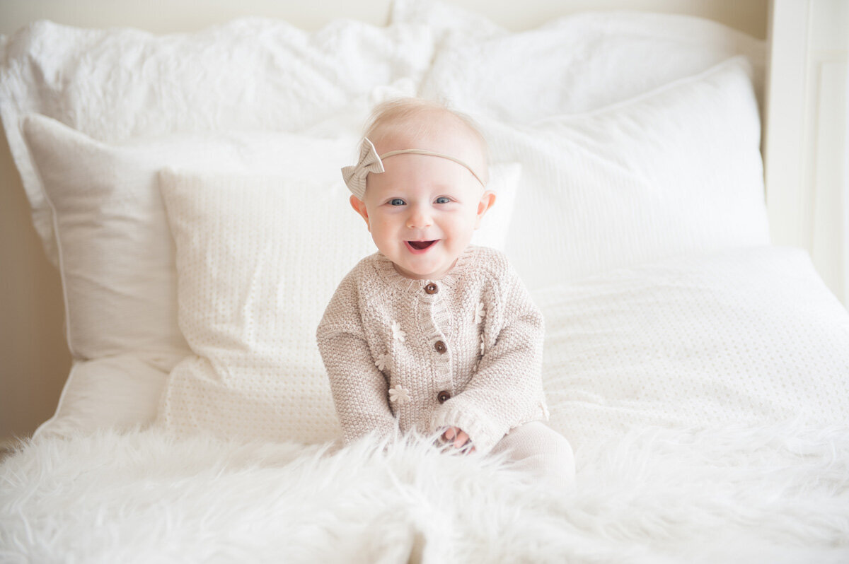 Family session of little girl sitting on the bed