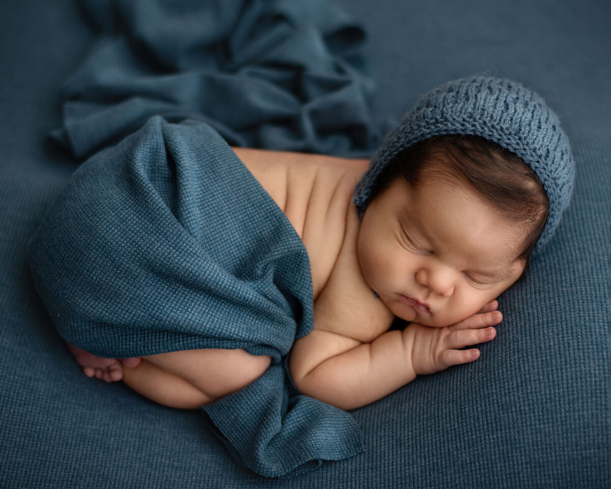 baby on blue  with bonnet by st louis newborn photographer