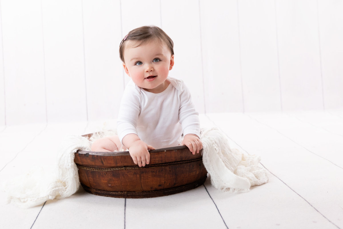 Little baby girl in a bowl with white
