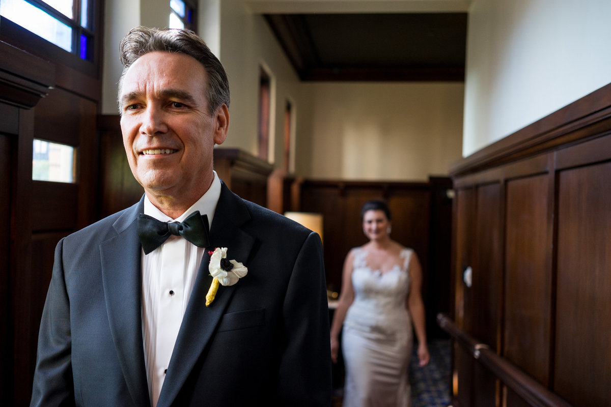 Bride walks up behind father of bride during first look with dad before wedding ceremony at Hotel Emma at The Historic Pearl
