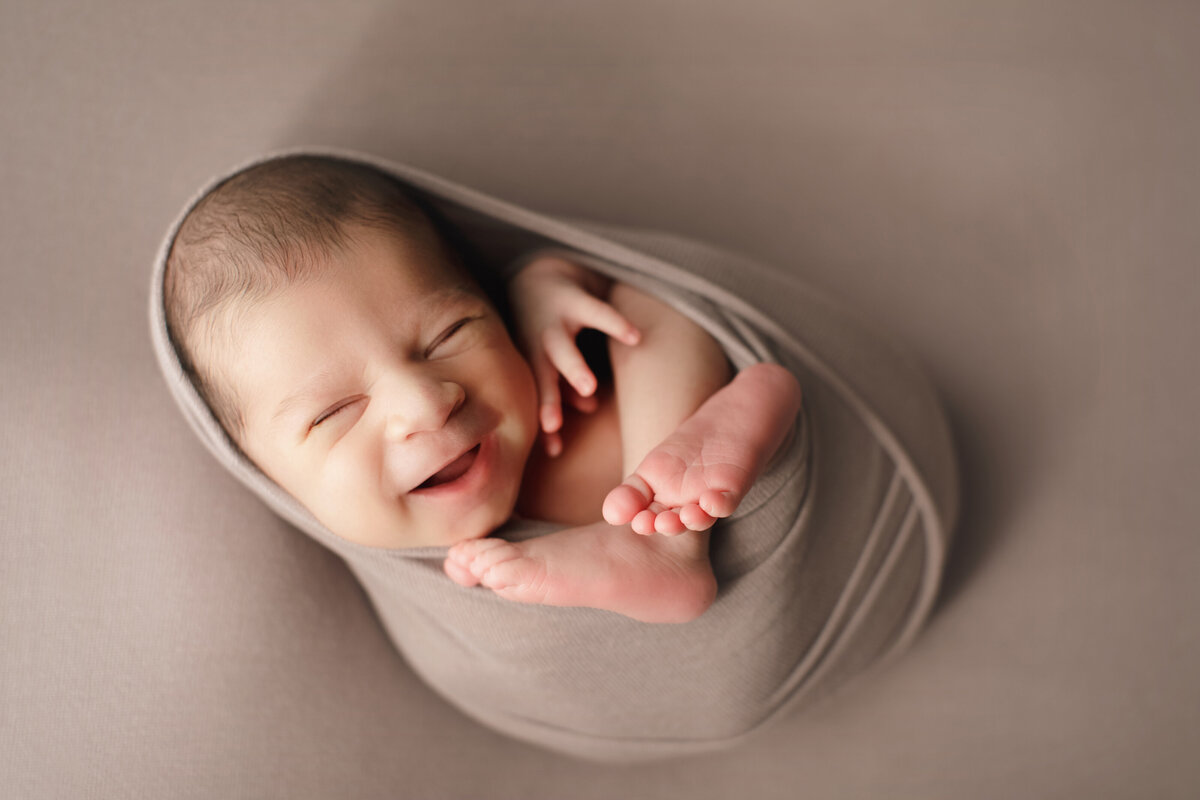 happy newborn baby with eyes closed smiling