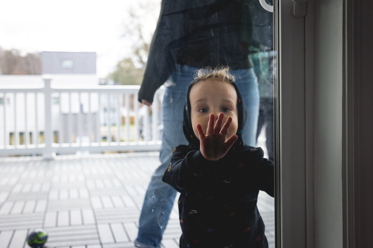 Toddler at sliding glass door