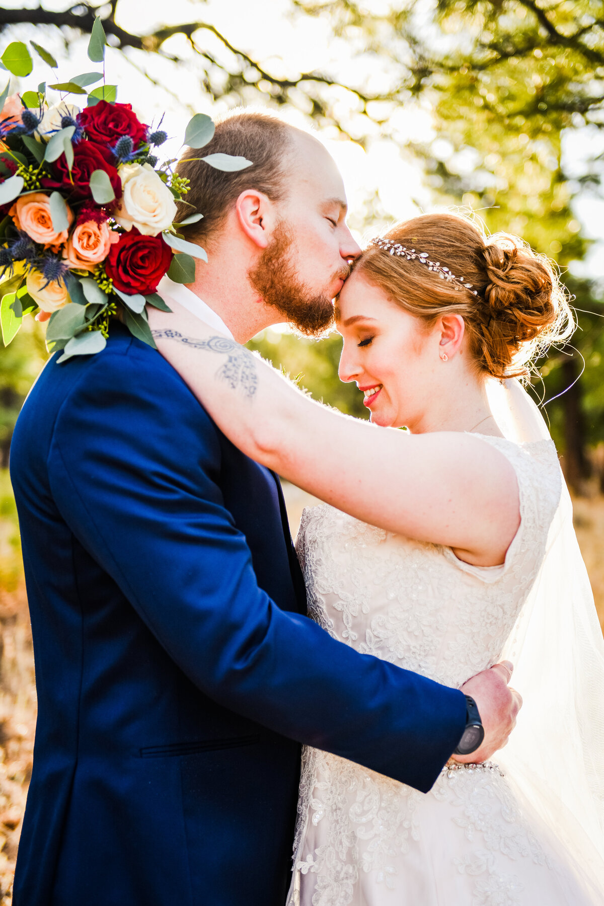 Bride and Groom holding each other kissing forehead bouquet golden hour Flagstaff pine trees wedding