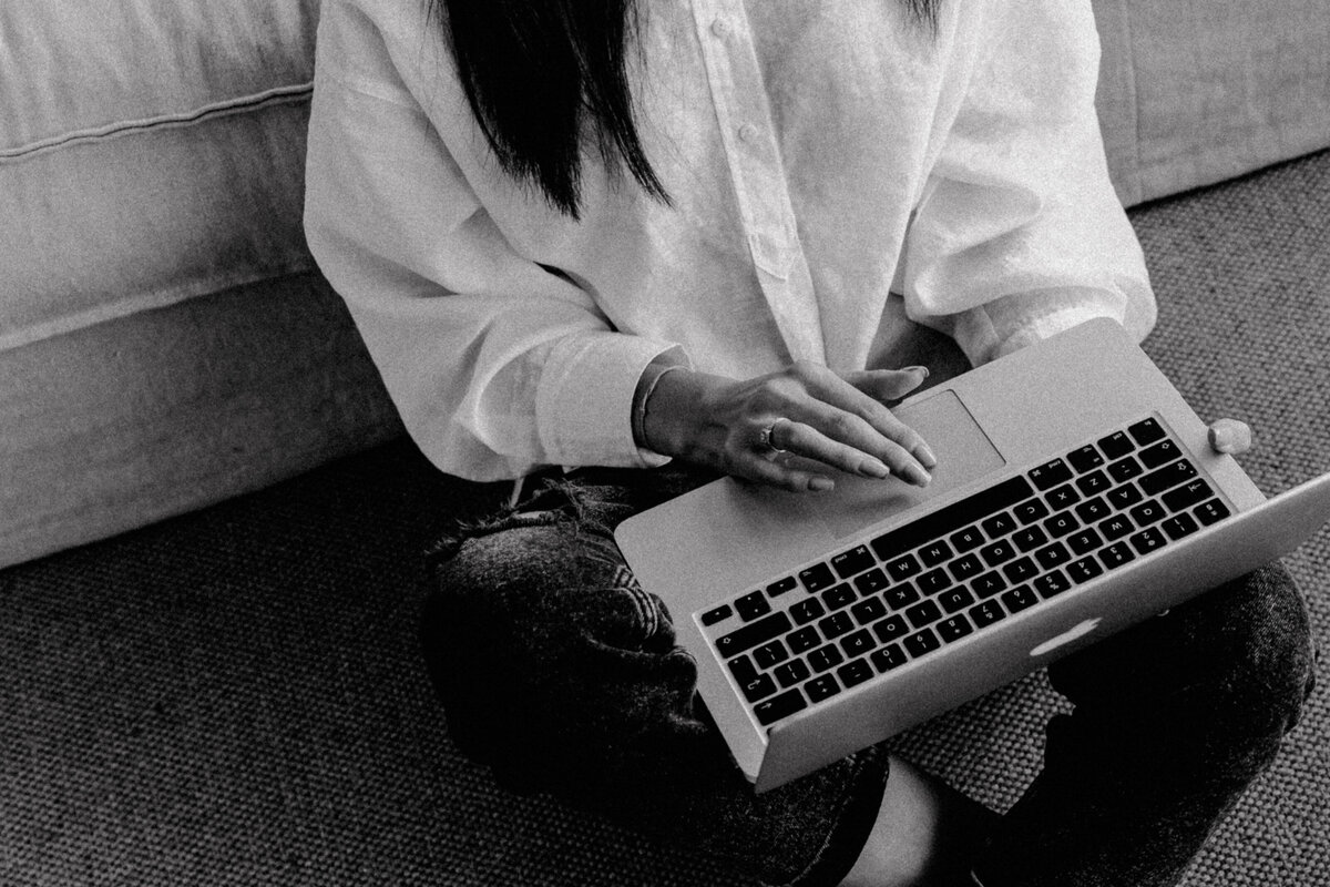 kaboompics_Adult young Asian woman sits in living room and works on laptop