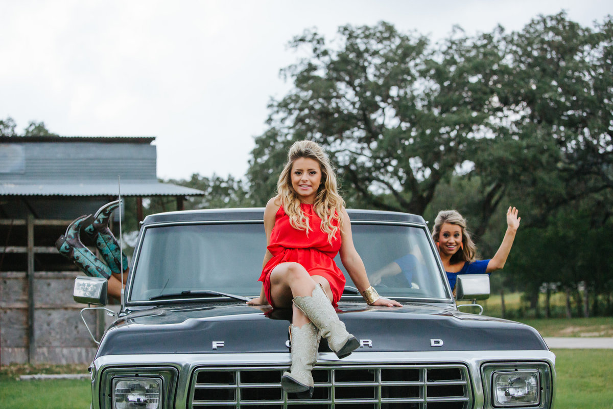 three high school senior girls sitting on truck by San Antonio senior photographer