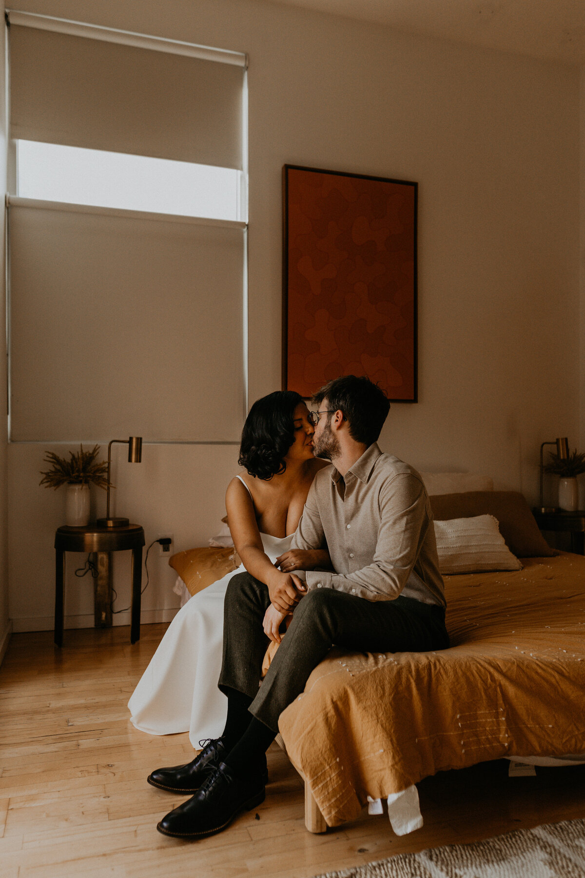 bride and groom sitting on  a bed together before their ceremony