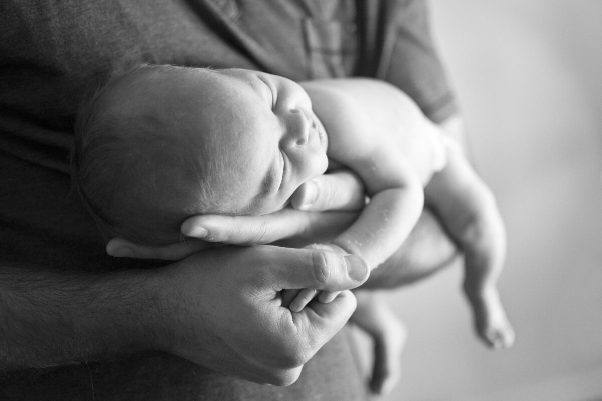 Dad holding baby in hands at home newborn photos Asheville, NC