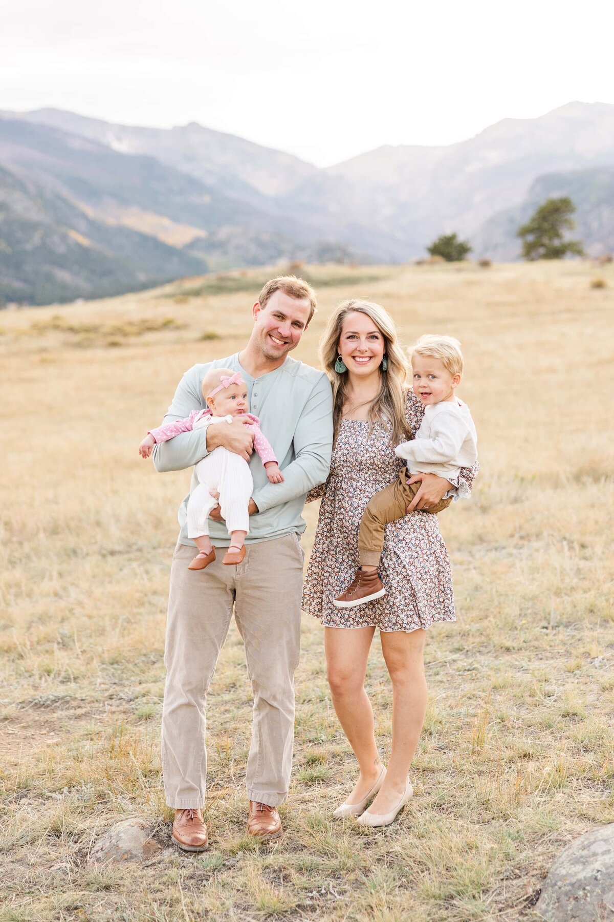 Family smiling in a field in  Colorado