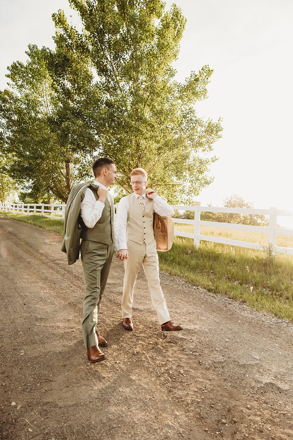Grooms walking hand-in-hand down path at Camelot Ranch.