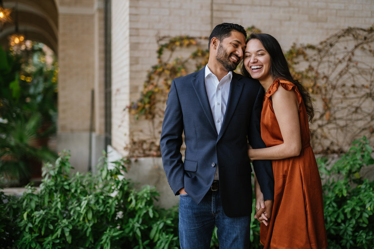 Smiling man and woman who are at their engagement photography session at the Historic Pearl in downtown San Antonio.