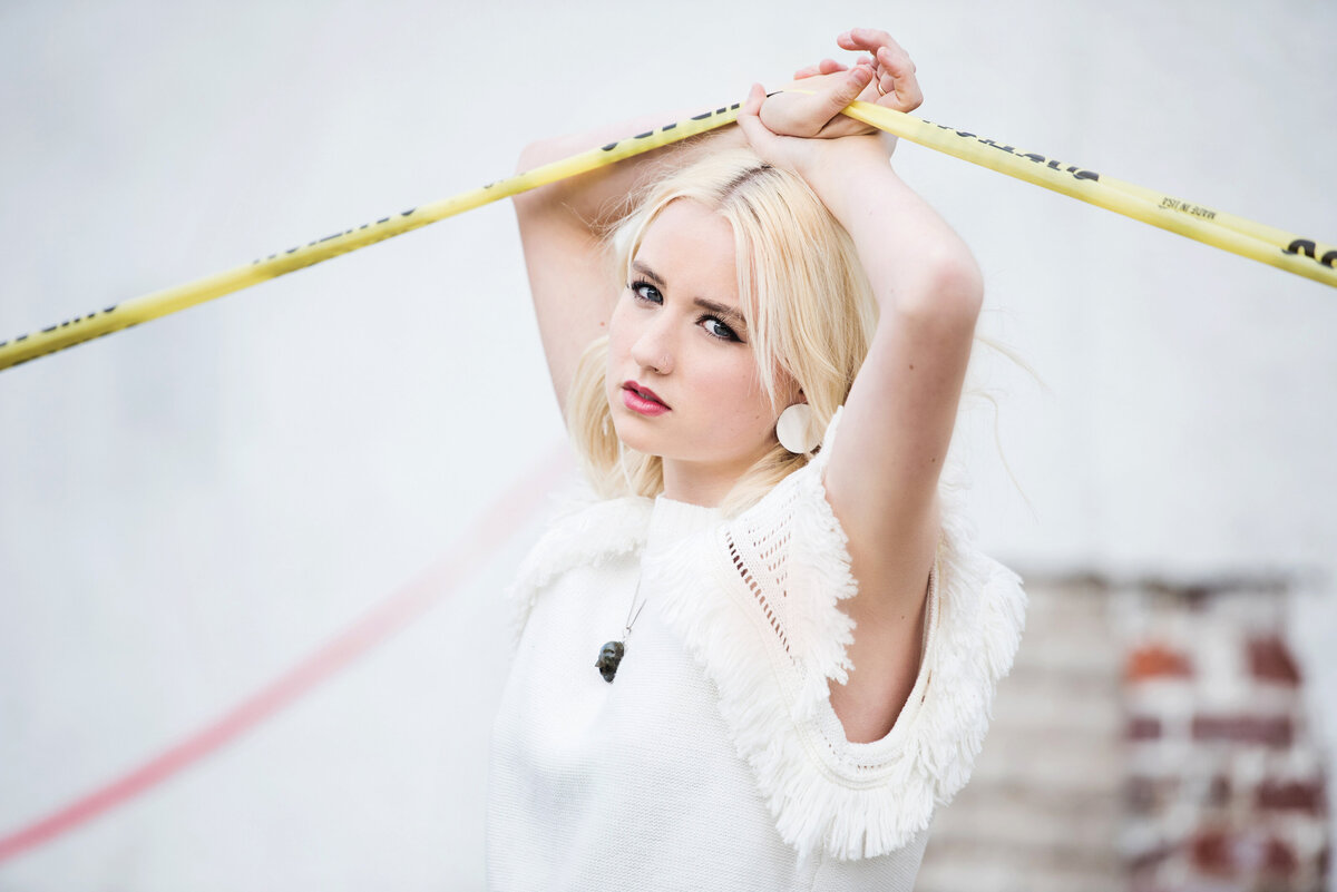 senior photo of girl with caution tape and urban wall