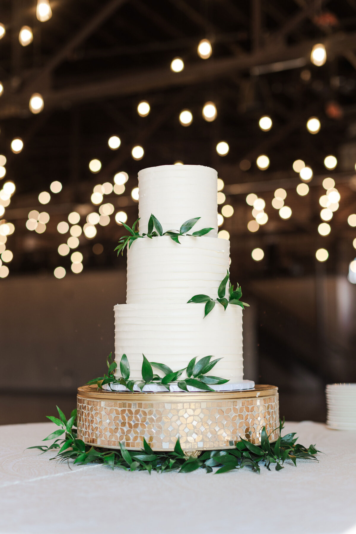 white cake with greenery sitting on a table in Knoxville