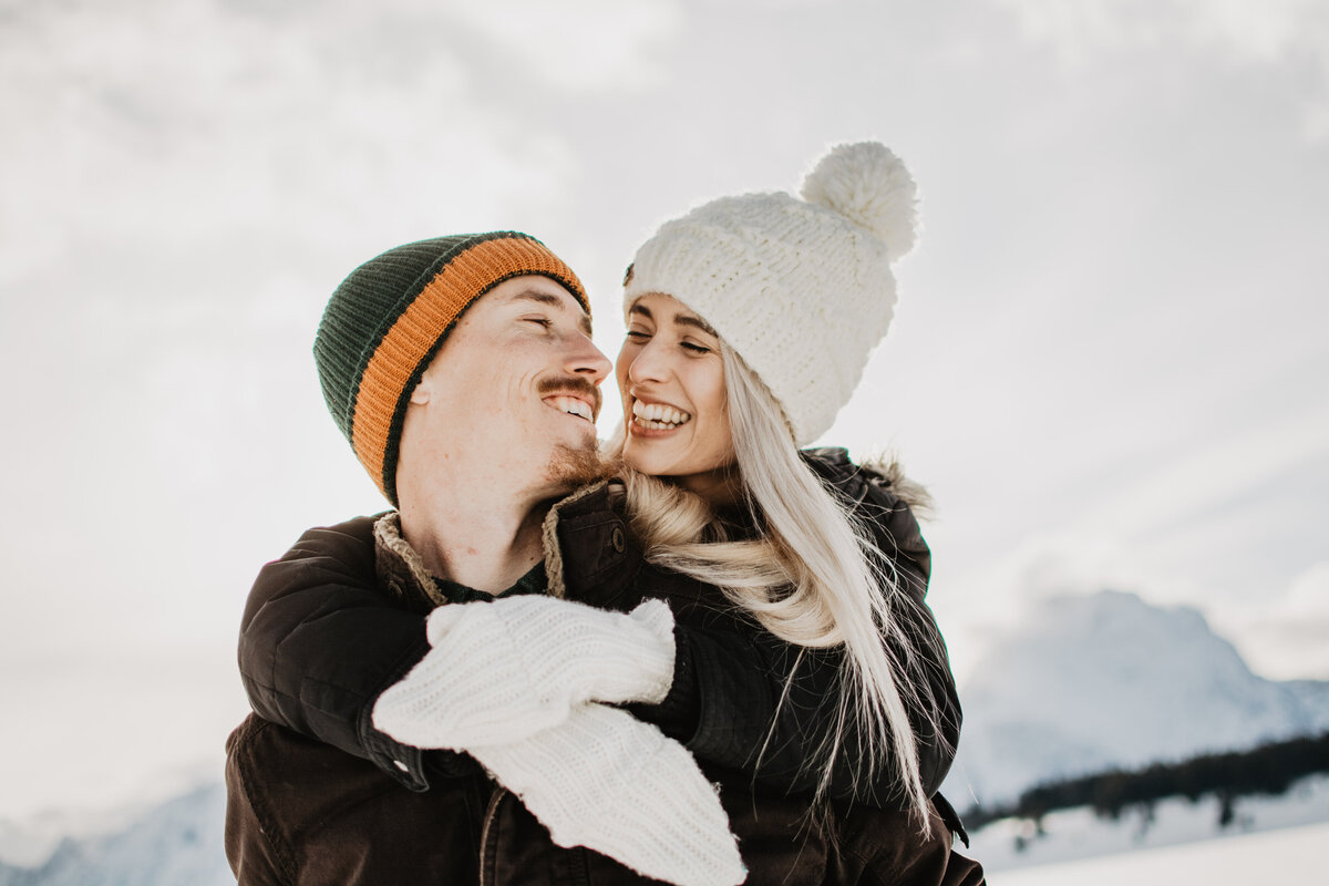 jackson hole photographers photographs man and woman laughing during their winter engagement session