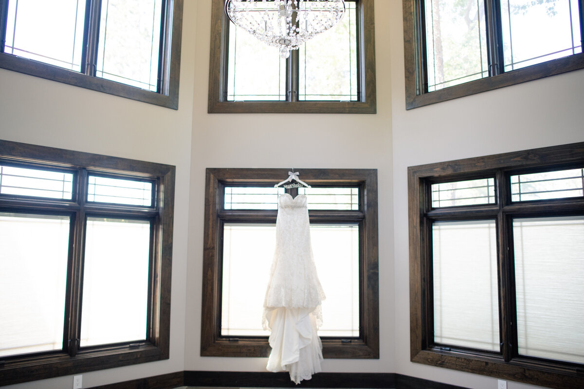 A white wedding dress in a room with six windows