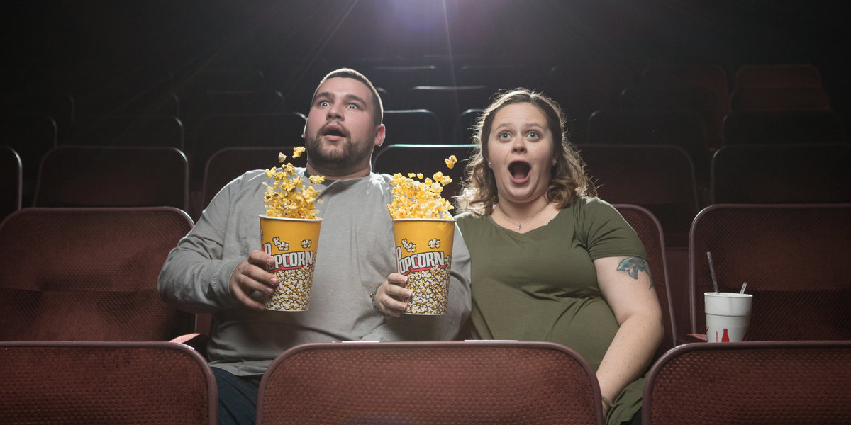 Lexi and Isaiah flinch during a scary scene during a movie in the Crecent Theatre in downtown Mobile, Alabama.