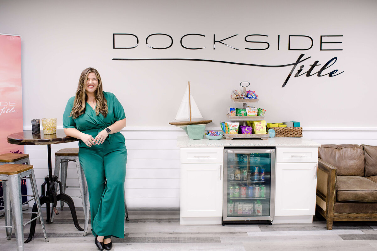 brand photo of woman in her business building leaning against a tall table with bar stools surrounding it with Orlando brand photographer