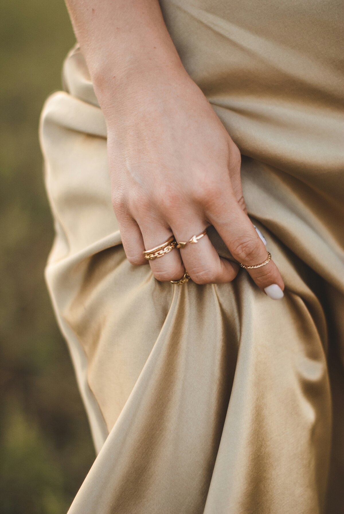 Woman's hand wearing gold jewelry