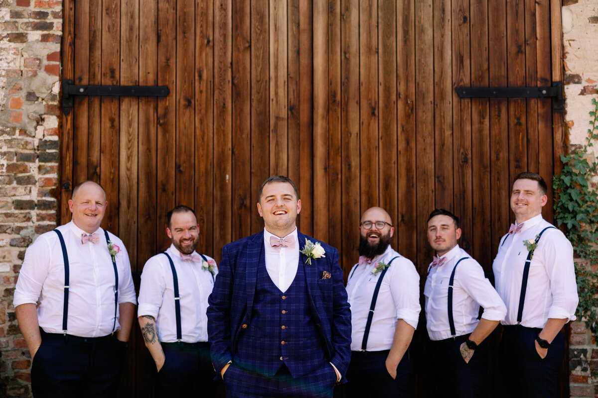 relaxed groomsmen photograph at The Normans with the groomsmen wearing braces