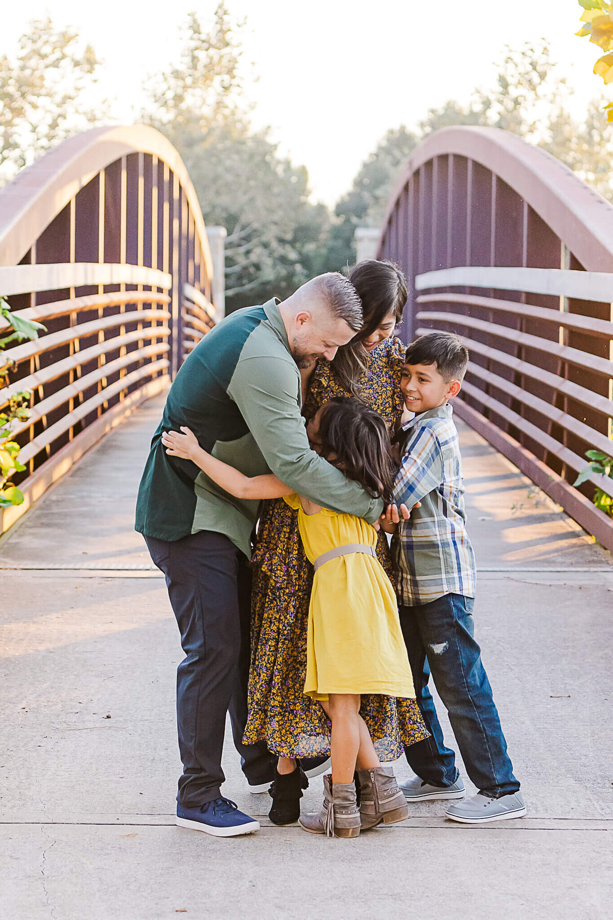 Family hug on a bridge