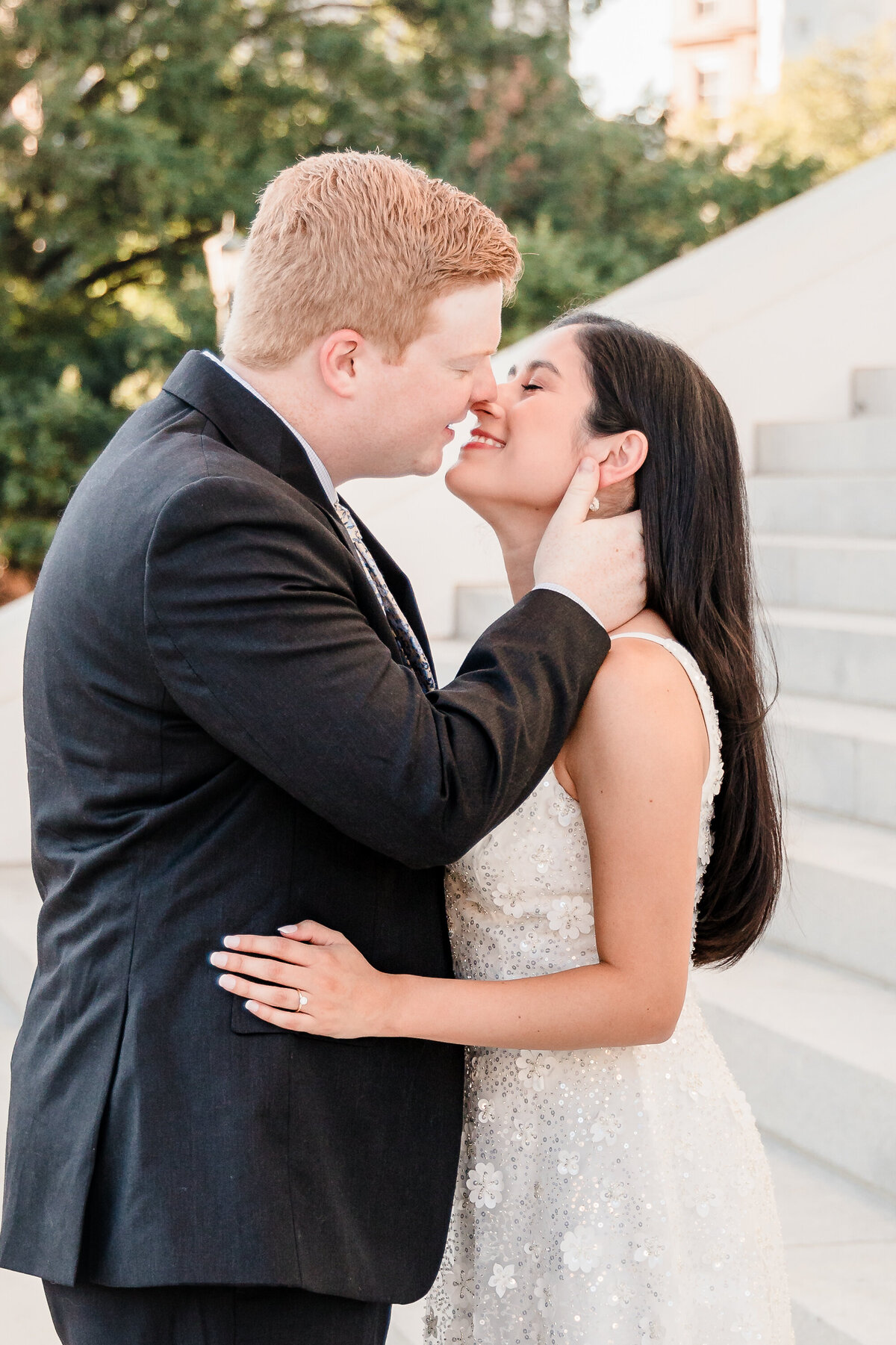 close up of a bride and groom smiling after a kiss in front of the virginia capitol building steps
