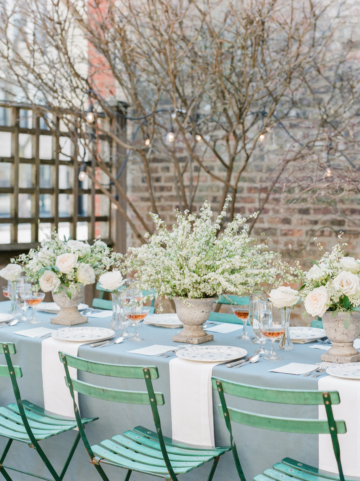 wedding table set with french blue tablecloth and green chairs