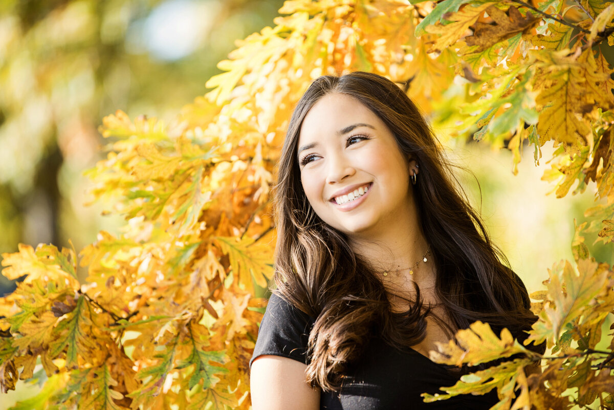 MInnetonka Minnesota high school L.A. Senior photo of girl smiling in yellow fall leaves