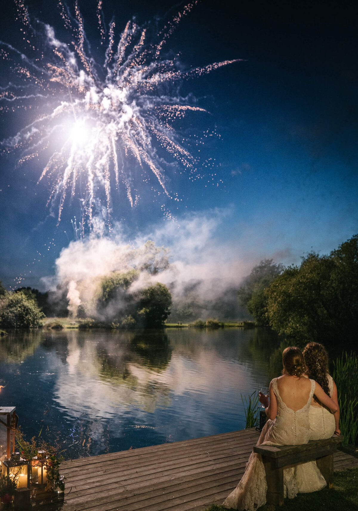 Two brides watching fireworks at their wedding