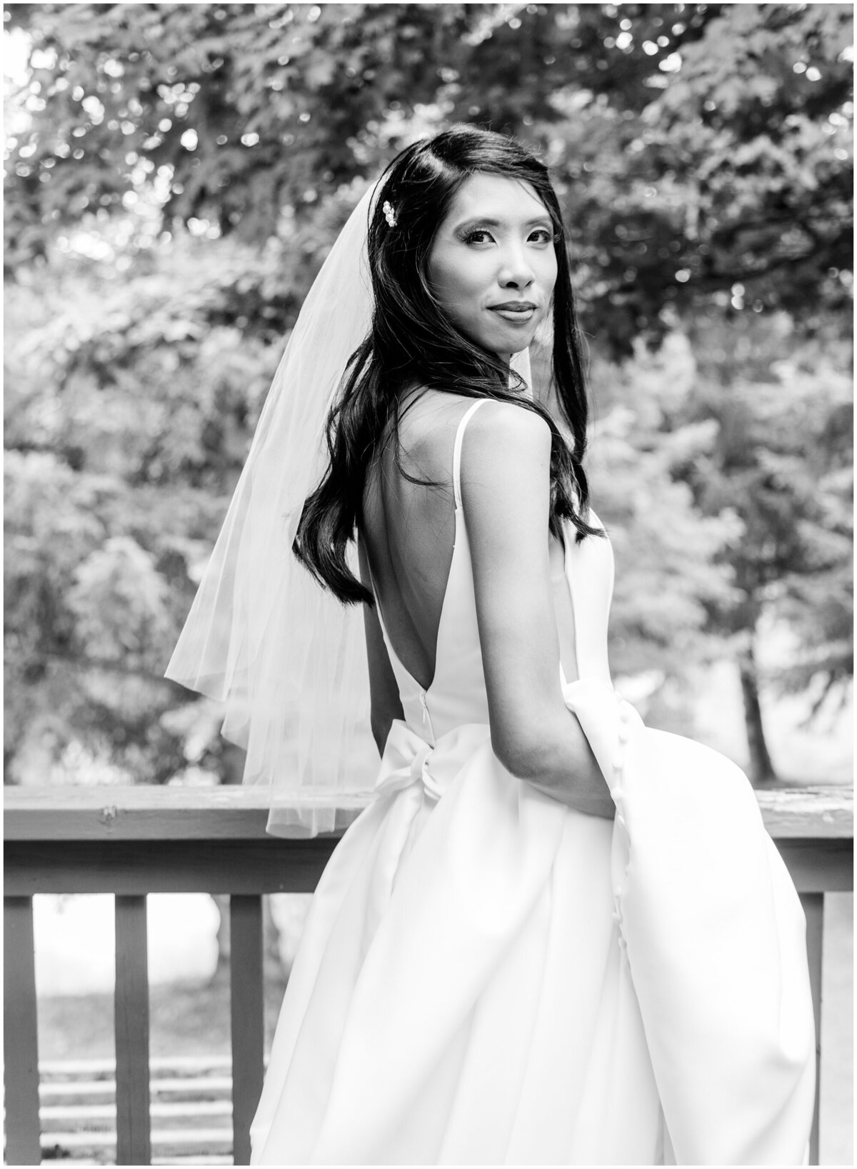 Bride's black and white portrait outdoors and showing off the back of her dress