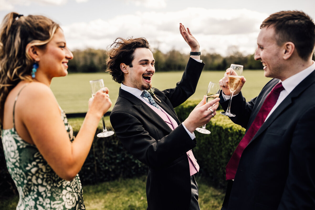 Group of friends celebrating with champagne at an outdoor Surrey wedding