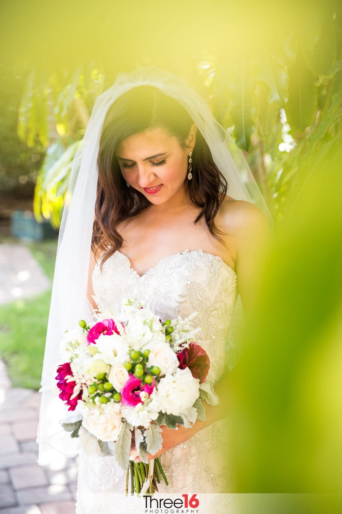 Bride takes a moment to reflect as she looks down at her bouquet