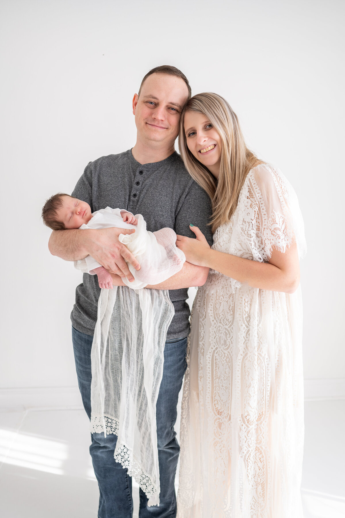 A new mother and father cuddle their newborn baby boy
