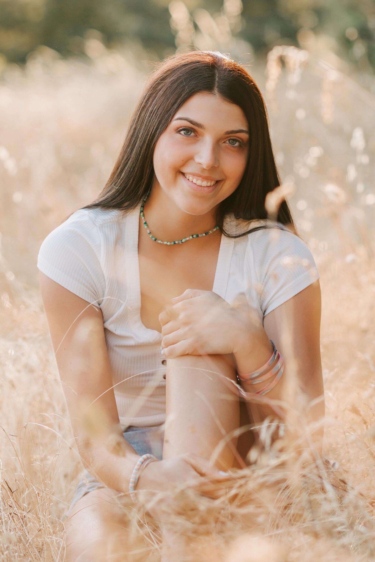 A high school senior sits in the grass at Fitton Green in Corvallis, OR