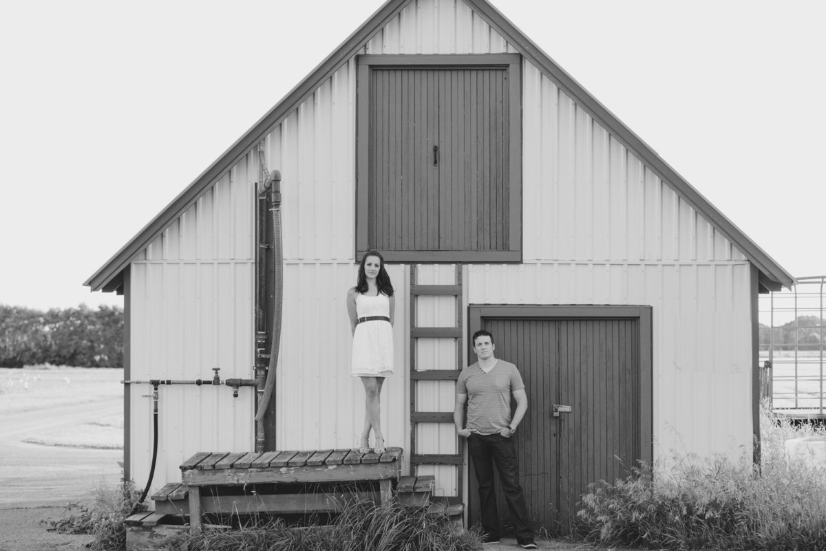 couple standing in front of old barn with ladder at experimental farm