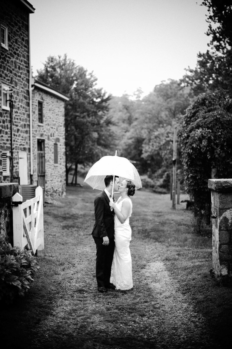 Couple under an umbrella during their rainy day wedding in PA