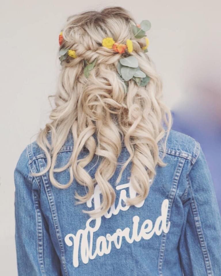 A woman with blonde haird and denim jacket that reads Just Married